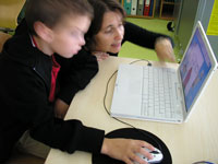 The class teacher discusses with a student using computer